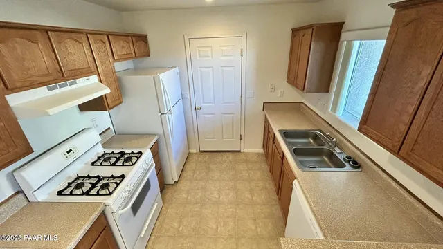 a view of a kitchen with wooden floor and cabinets