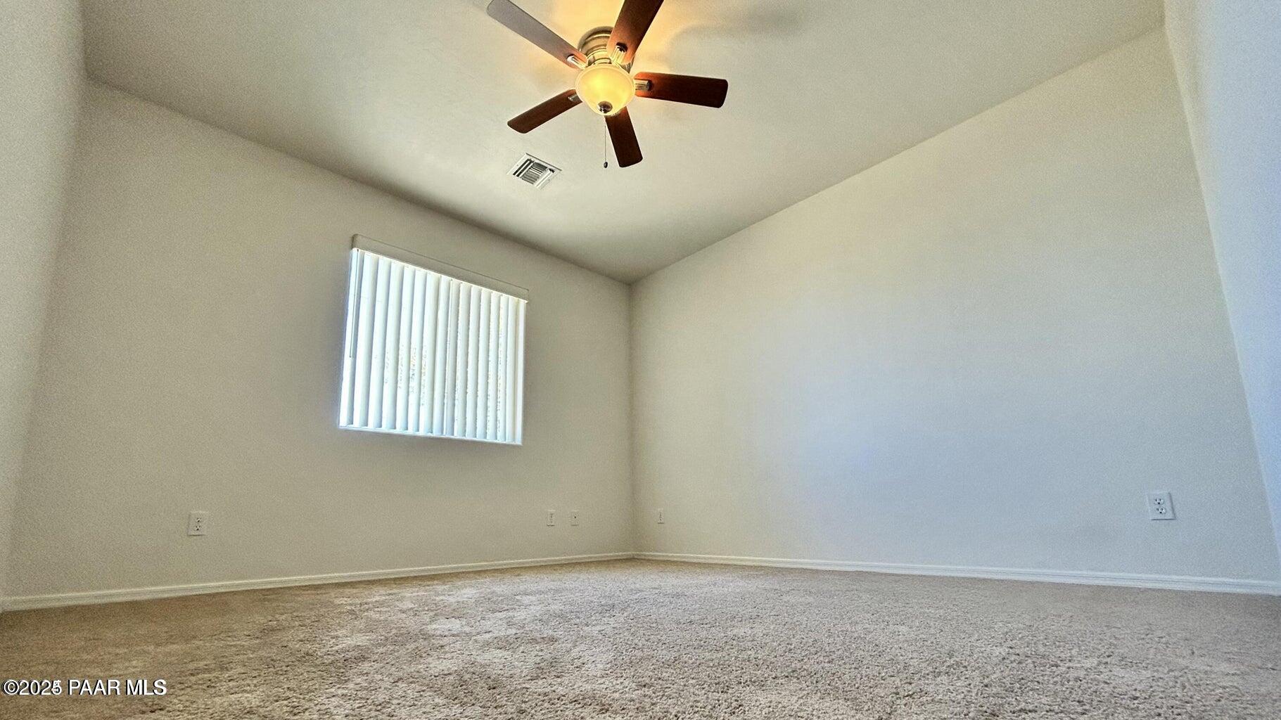 3101 North Corrine Drive, Unit 1 Prescott Valley, AZ 86314 - Photo 8 of 16 an empty room with a window and a fan