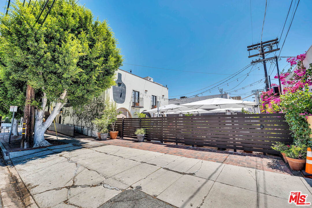 309 South Hamel Road Los Angeles, CA 90048 - Photo 10 of 34 a view of a yard with plants and a bench under an umbrella