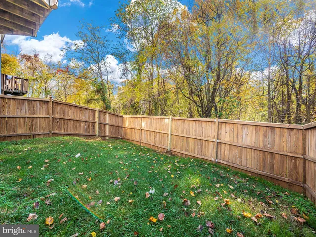 a view of backyard with wooden fence