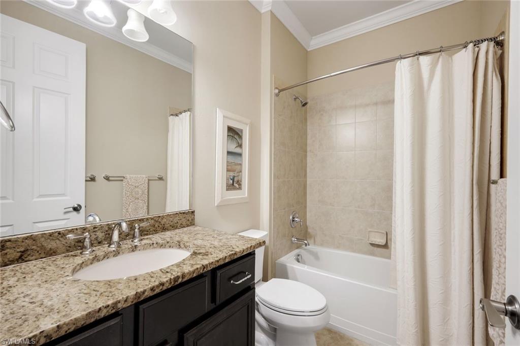10820 Rutherford Road Fort Myers, FL 33913 - Photo 28 of 42 Bathroom featuring a built-in vanity with a stone countertop and undermount sink, brushed nickel fixtures, a full-width mirror, and a tiled shower/tub combination