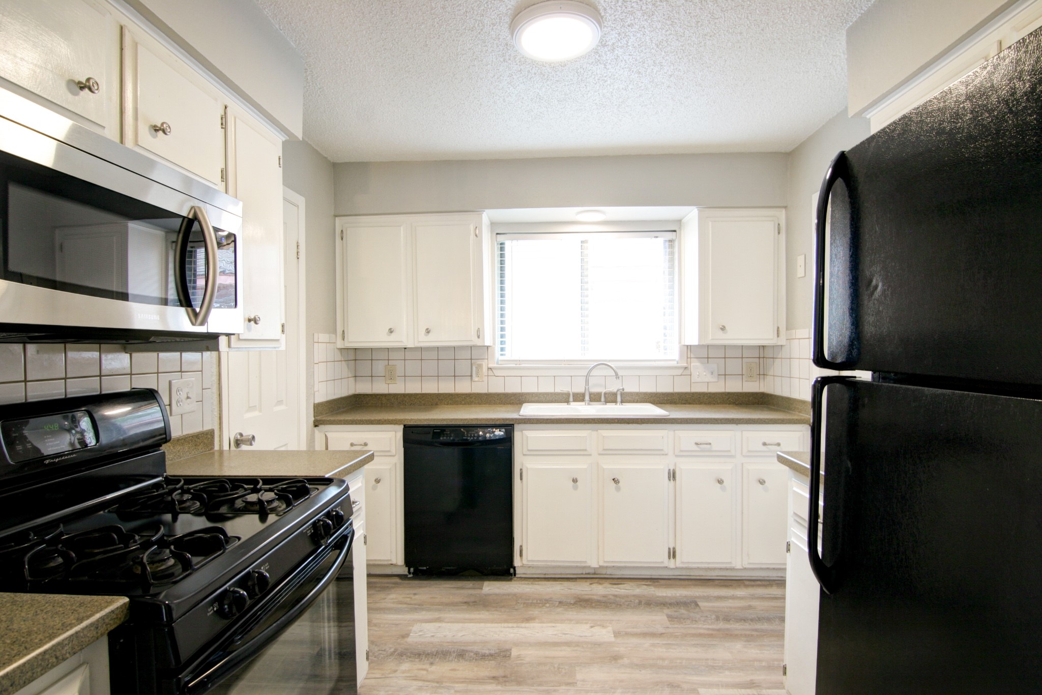 908 Echo Lane Austin, TX 78745 - Photo 19 of 24 a kitchen with granite countertop a stove top oven microwave and cabinets