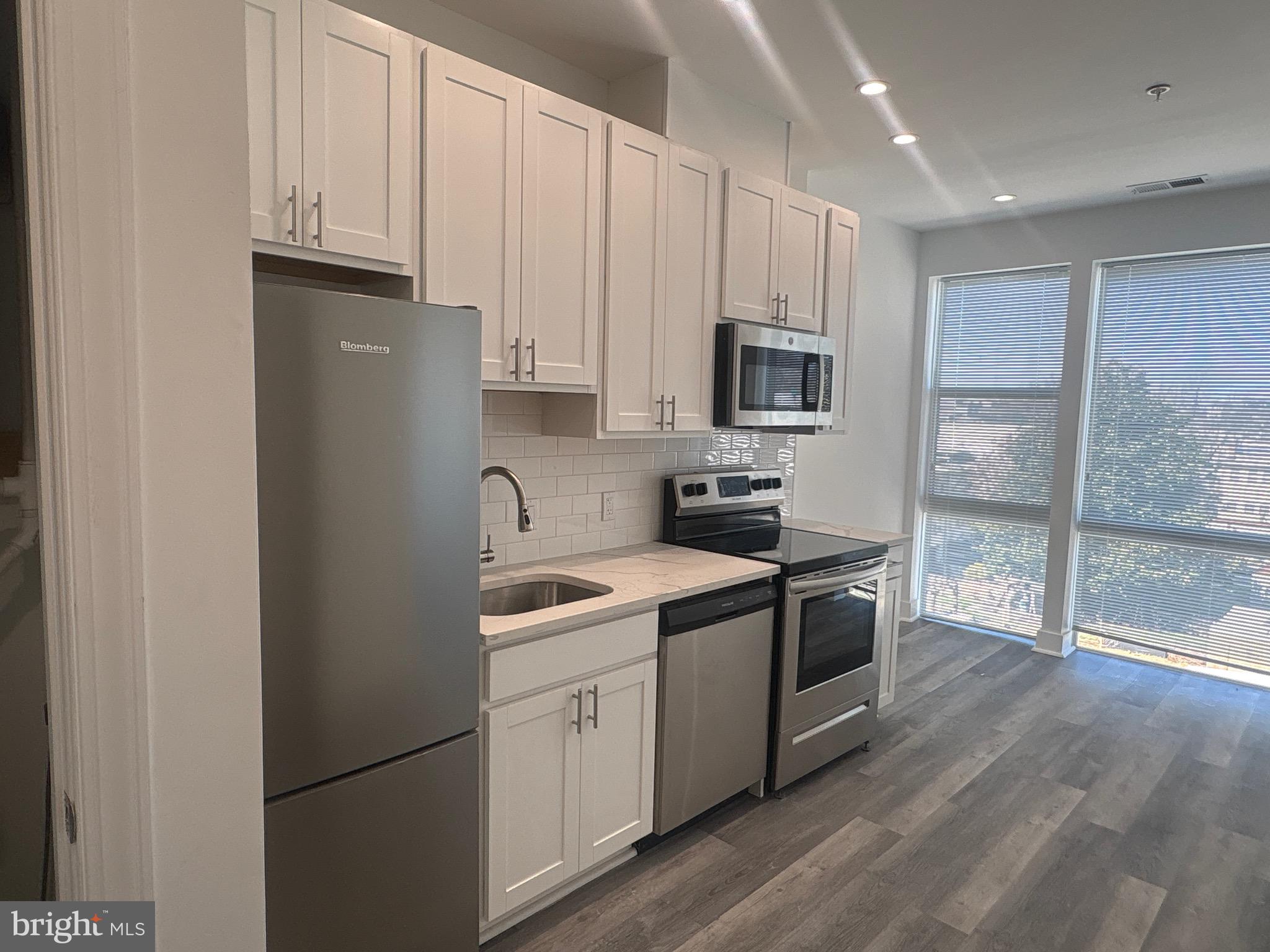 818 Bladensburg Road Northeast, Unit 408 Washington, DC 20002 - Photo 3 of 10 a kitchen with stainless steel appliances granite countertop a refrigerator a sink a stove a microwave and with a refrigerator