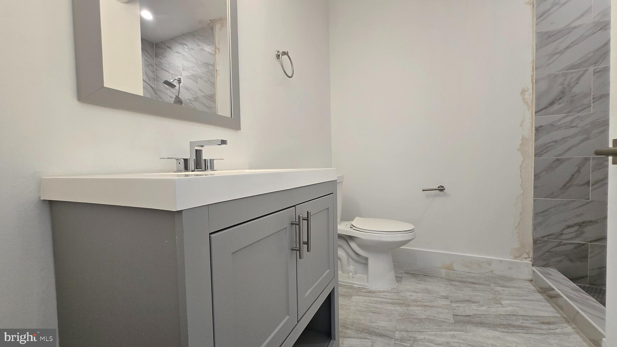 818 Bladensburg Road Northeast, Unit 408 Washington, DC 20002 - Photo 7 of 10 a bathroom with a toilet a sink and mirror