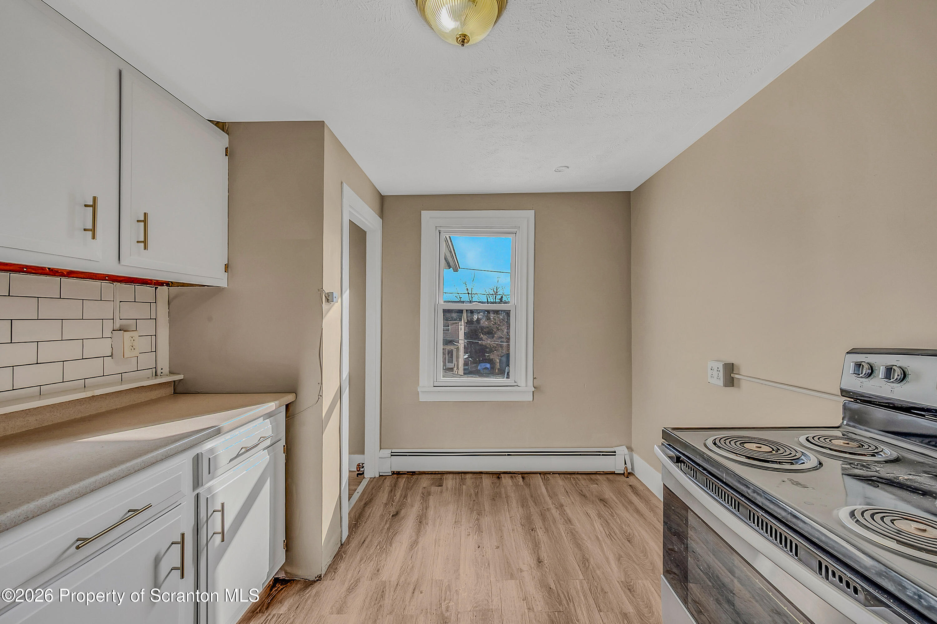 107 2nd Street, Unit 2 Blakely, PA 18447 - Photo 12 of 14 a kitchen with a stove and white cabinets