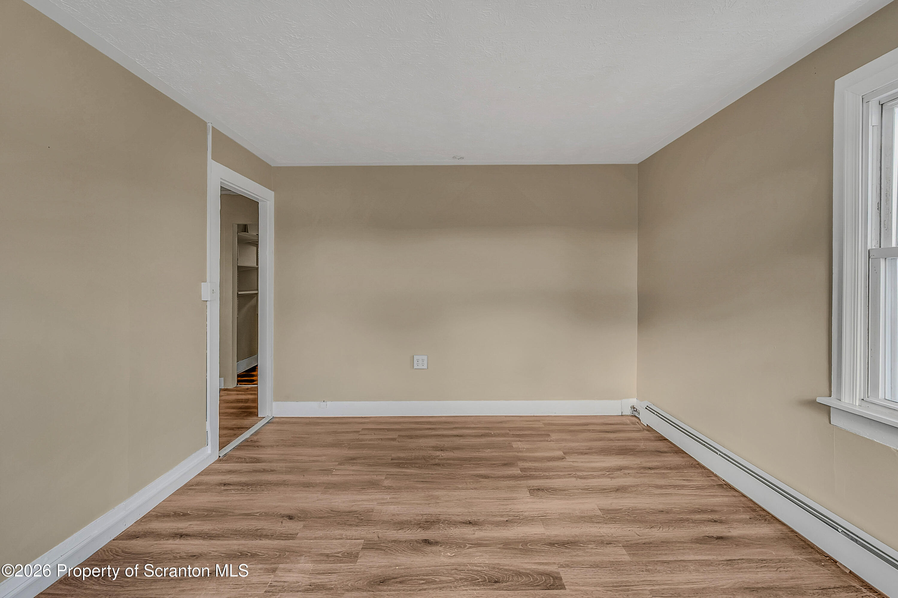 107 2nd Street, Unit 2 Blakely, PA 18447 - Photo 5 of 14 a view of an empty room with wooden floor and a window