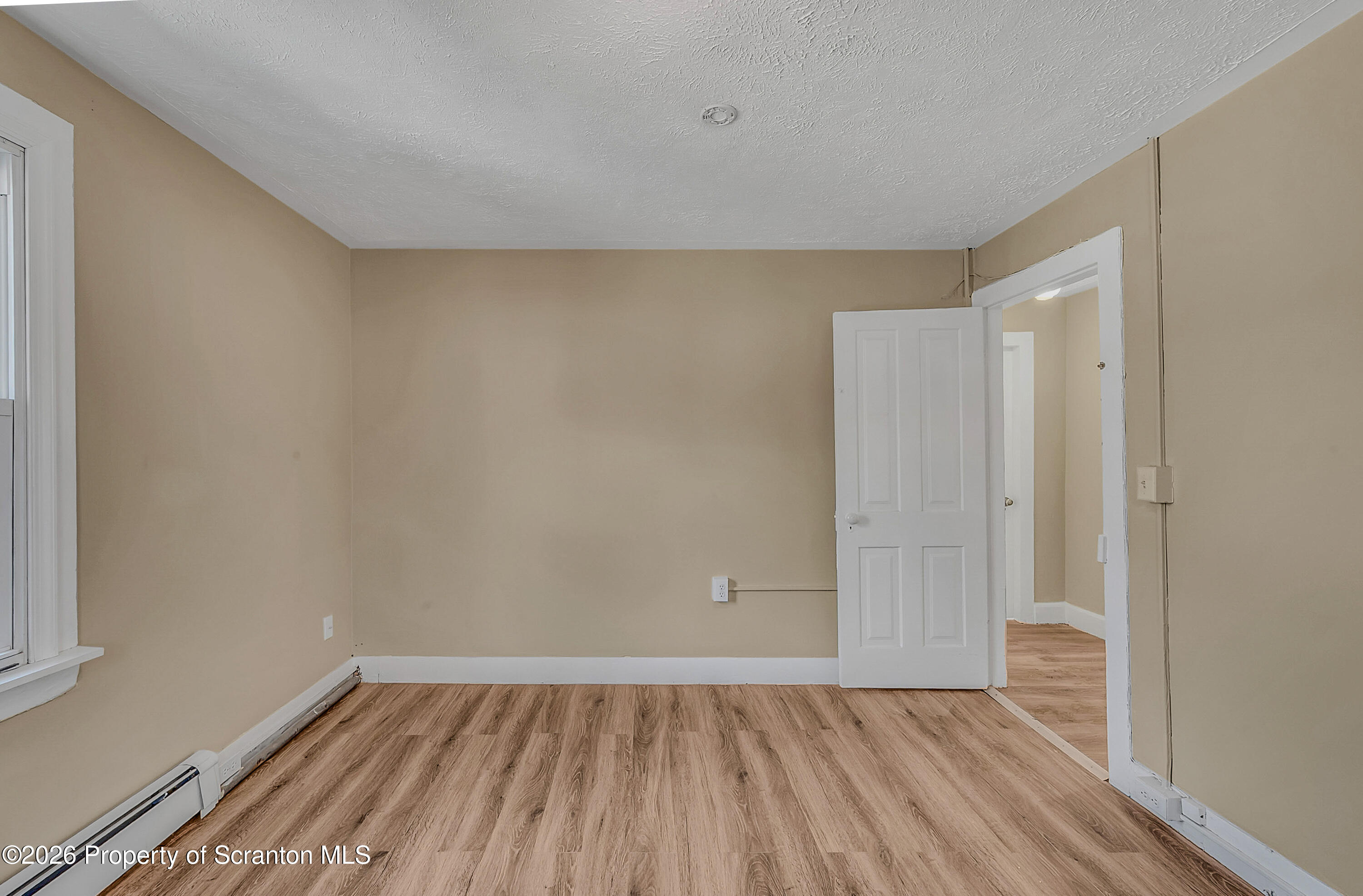 107 2nd Street, Unit 2 Blakely, PA 18447 - Photo 10 of 14 a view of an empty room with wooden floor and a window