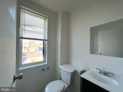 a bathroom with a toilet a sink and mirror
