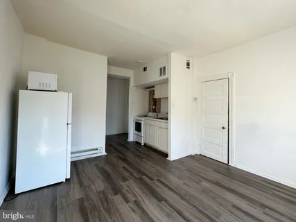 a view of a kitchen with wooden floor and a refrigerator