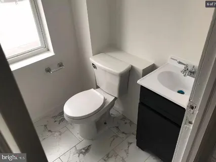 a white toilet sitting next to a bathroom sink