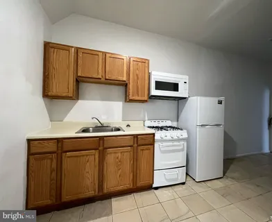 a kitchen with a stove sink and cabinets