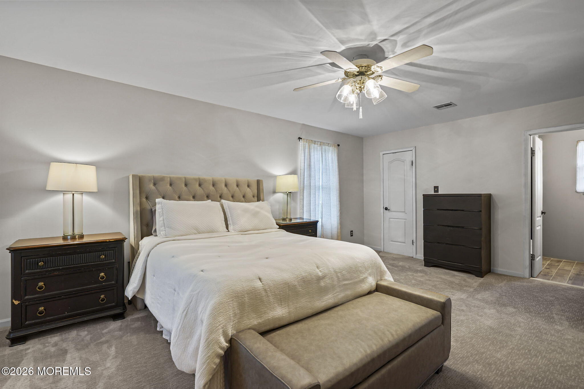 438 Bennetts Mills Road Jackson, NJ 08527 - Photo 17 of 42 a bedroom with a bed and a chandelier
