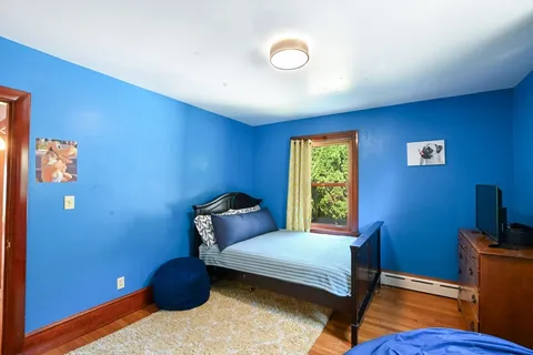 a bedroom with a bed a mirror and a window