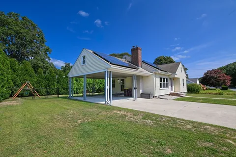 a view of a house with backyard and sitting area