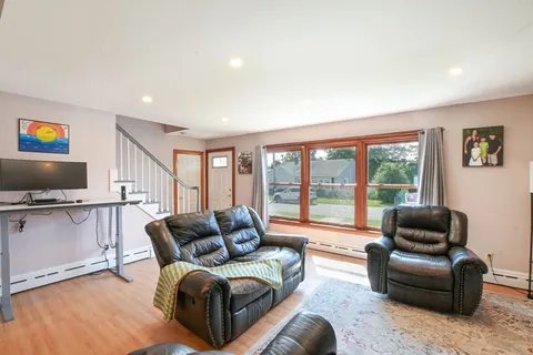 a living room with furniture a flat screen tv and a large window