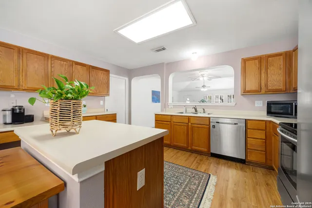 a kitchen with a stove a sink a microwave a dining table and chairs