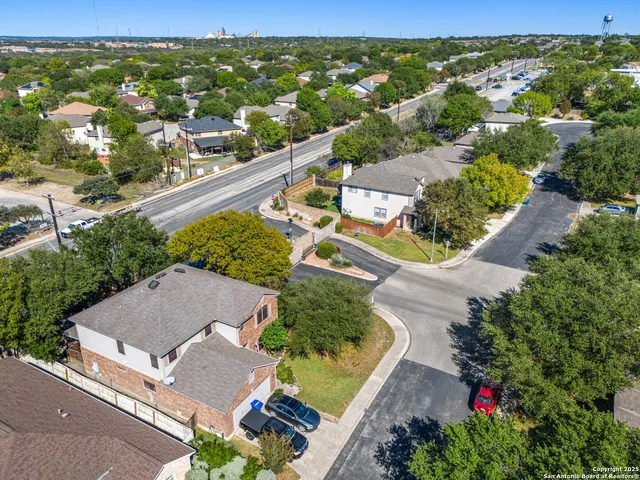 an aerial view of residential houses with outdoor space and street view