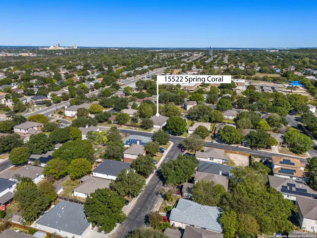 an aerial view of residential houses with outdoor space and ocean view