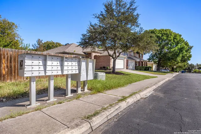 a view of a house with a yard and potted plants