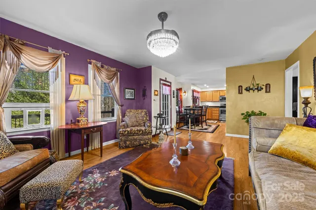 a living room with furniture a chandelier and a table