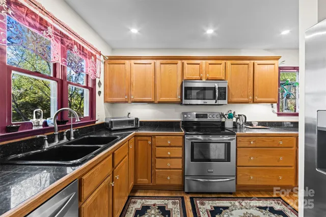 a kitchen with stainless steel appliances a stove sink microwave and cabinets