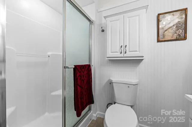 a bathroom with a toilet and a shower curtain