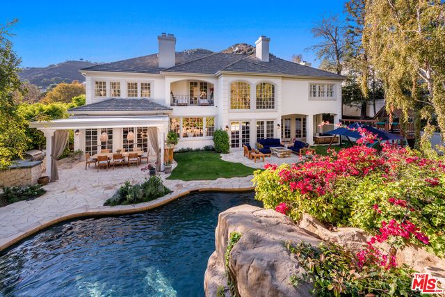 a front view of a house with a yard and fountain