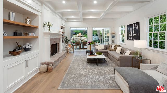 a living room with furniture fireplace and a large window