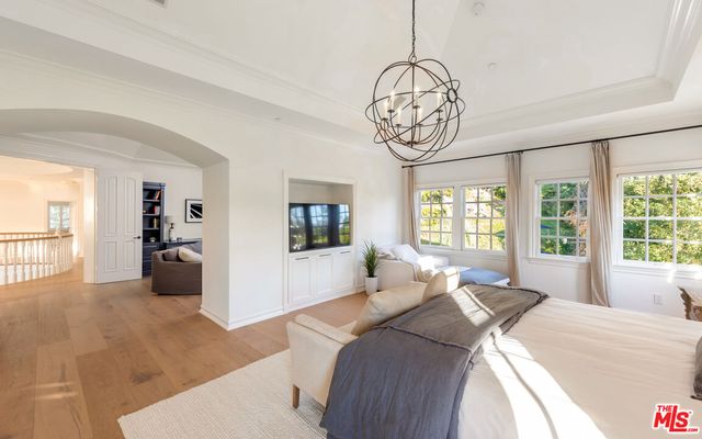 a bedroom with bed and a large window