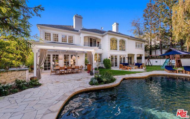 a view of a house with swimming pool and sitting area