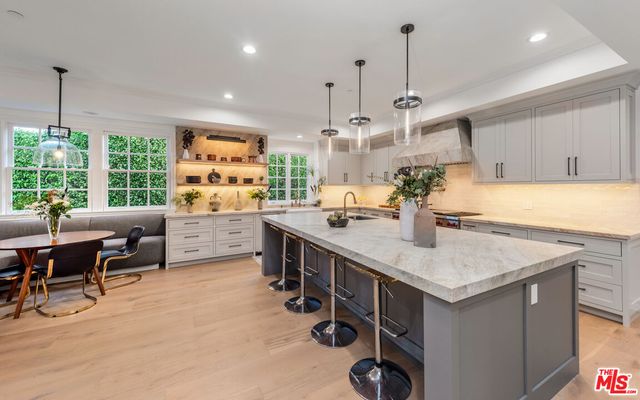 a kitchen with kitchen island a large counter top space appliances and a center island