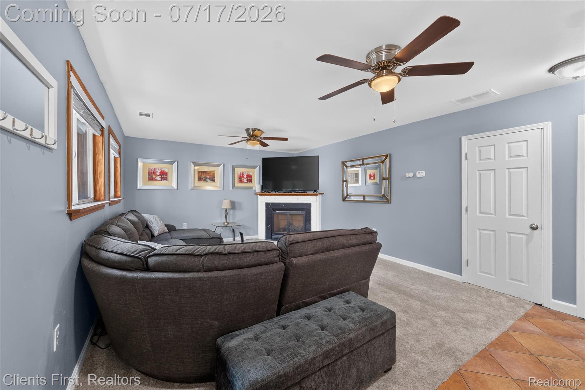 36852 Chase Street Romulus, MI 48174 - Photo 4 of 40 Living area featuring a fireplace with a white mantel, ceiling fans, and light blue painted walls