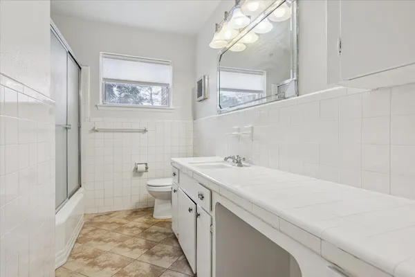 a bathroom with a sink a toilet and a mirror