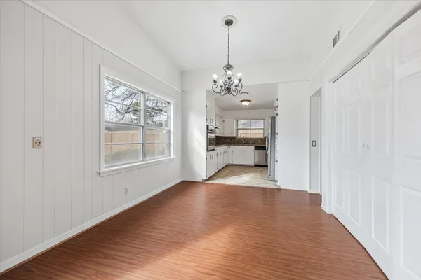 a view of a livingroom with furniture wooden floor windows and chandelier