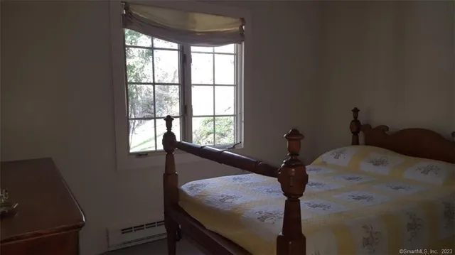 a bed sitting in a bedroom next to a window