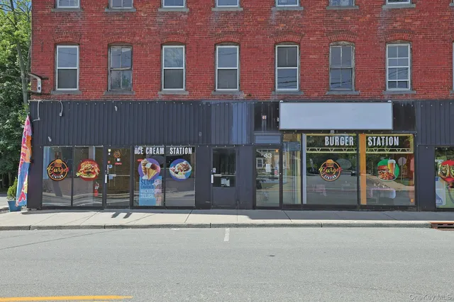 an outdoor cafe with a table and chairs under an umbrella