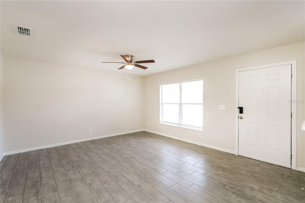 146 Hidden Lk Loop Haines City, FL 33844 - Photo 2 of 16 a view of empty room with wooden floor and fan