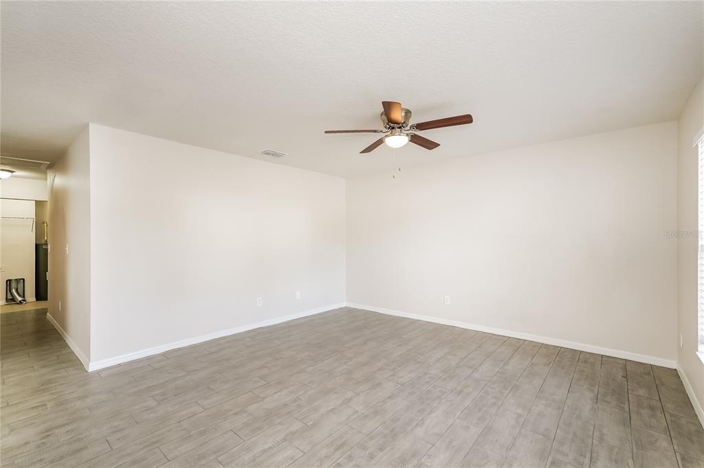 146 Hidden Lk Loop Haines City, FL 33844 - Photo 3 of 16 a view of a room with a ceiling fan and wooden floor