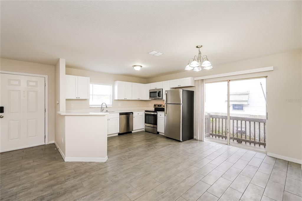 146 Hidden Lk Loop Haines City, FL 33844 - Photo 4 of 16 a kitchen with white cabinets and stainless steel appliances