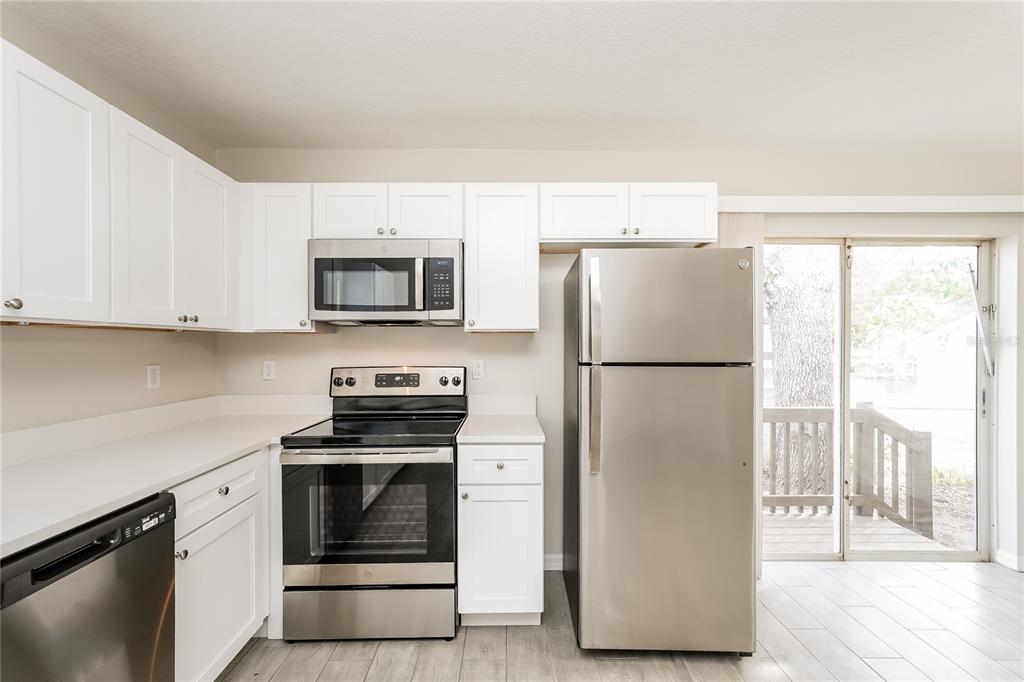 146 Hidden Lk Loop Haines City, FL 33844 - Photo 7 of 16 a kitchen with a stove a microwave and a refrigerator