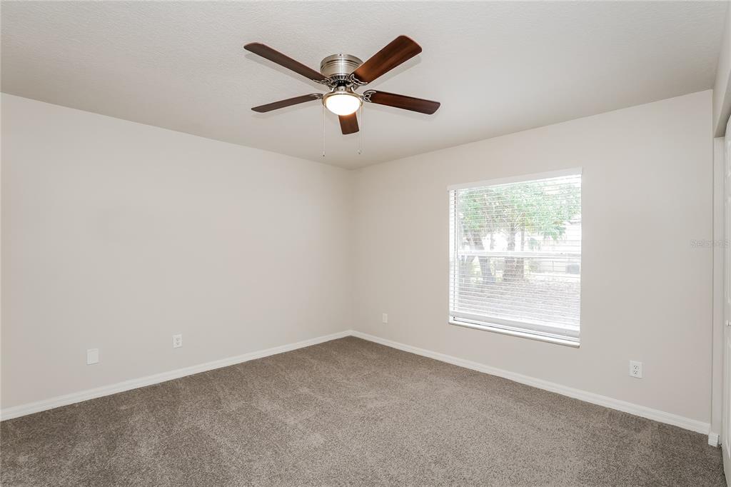 146 Hidden Lk Loop Haines City, FL 33844 - Photo 8 of 16 an empty room with ceiling fan and windows