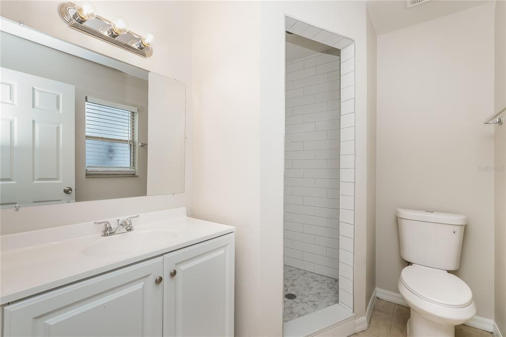 146 Hidden Lk Loop Haines City, FL 33844 - Photo 10 of 16 a bathroom with a toilet a sink a mirror and vanity