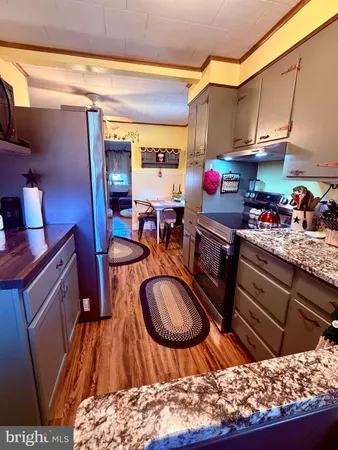 a kitchen with stainless steel appliances kitchen island granite countertop a sink stove and cabinets