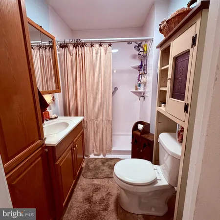 a bathroom with a granite countertop toilet sink and mirror