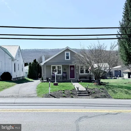 a front view of a house with a garden and trees