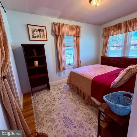 a bedroom with a bed and a dresser with rug