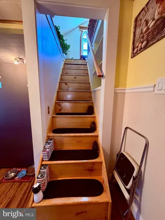 a view of staircase with wooden floor and chair