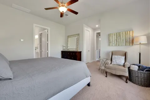 a bedroom with a bed ceiling fan and a window