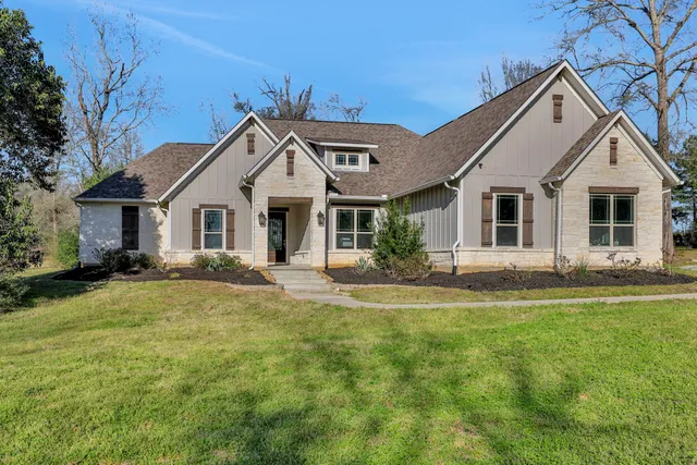 a front view of a house with a garden and yard