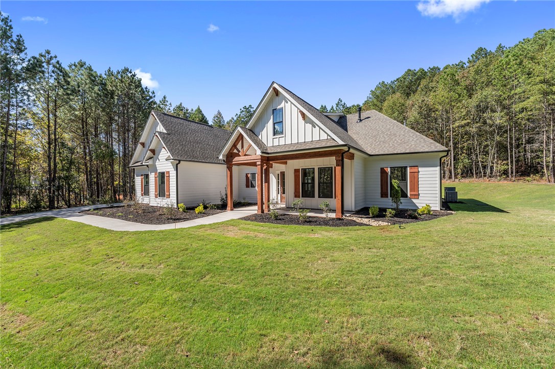 1031 Hill Road Anderson, SC 29621 - Photo 2 of 35 A striking exterior presents a fresh facade with dark roof, natural wood accents, and lush green surroundings.